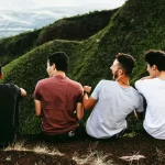 4 friends sitting together at a viewpoint.