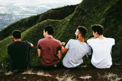 4 friends sitting together at a viewpoint.
