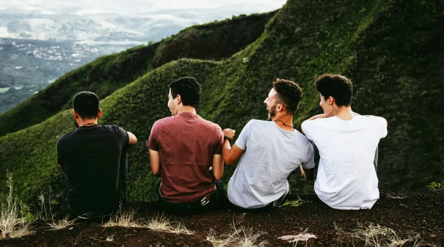4 friends sitting together at a viewpoint.