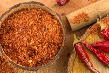 Both ground and whole cayenne peppers on a counter.