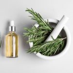 rosemary in a mortar and pestle and essential oil