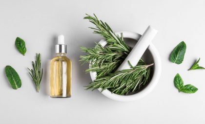 rosemary in a mortar and pestle and essential oil