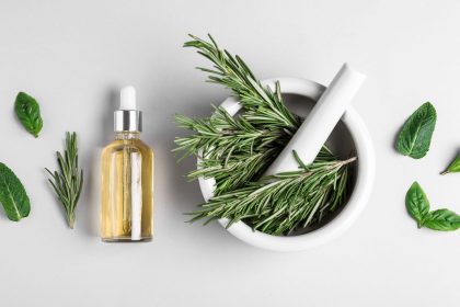 rosemary in a mortar and pestle and essential oil