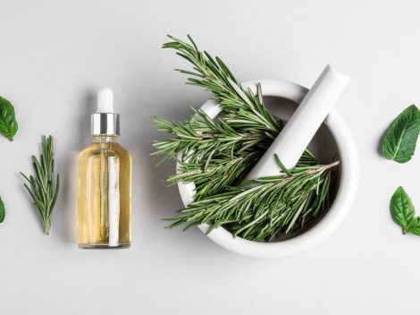 rosemary in a mortar and pestle and essential oil