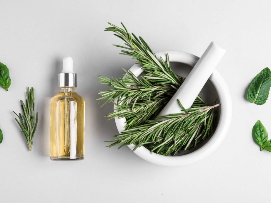 rosemary in a mortar and pestle and essential oil