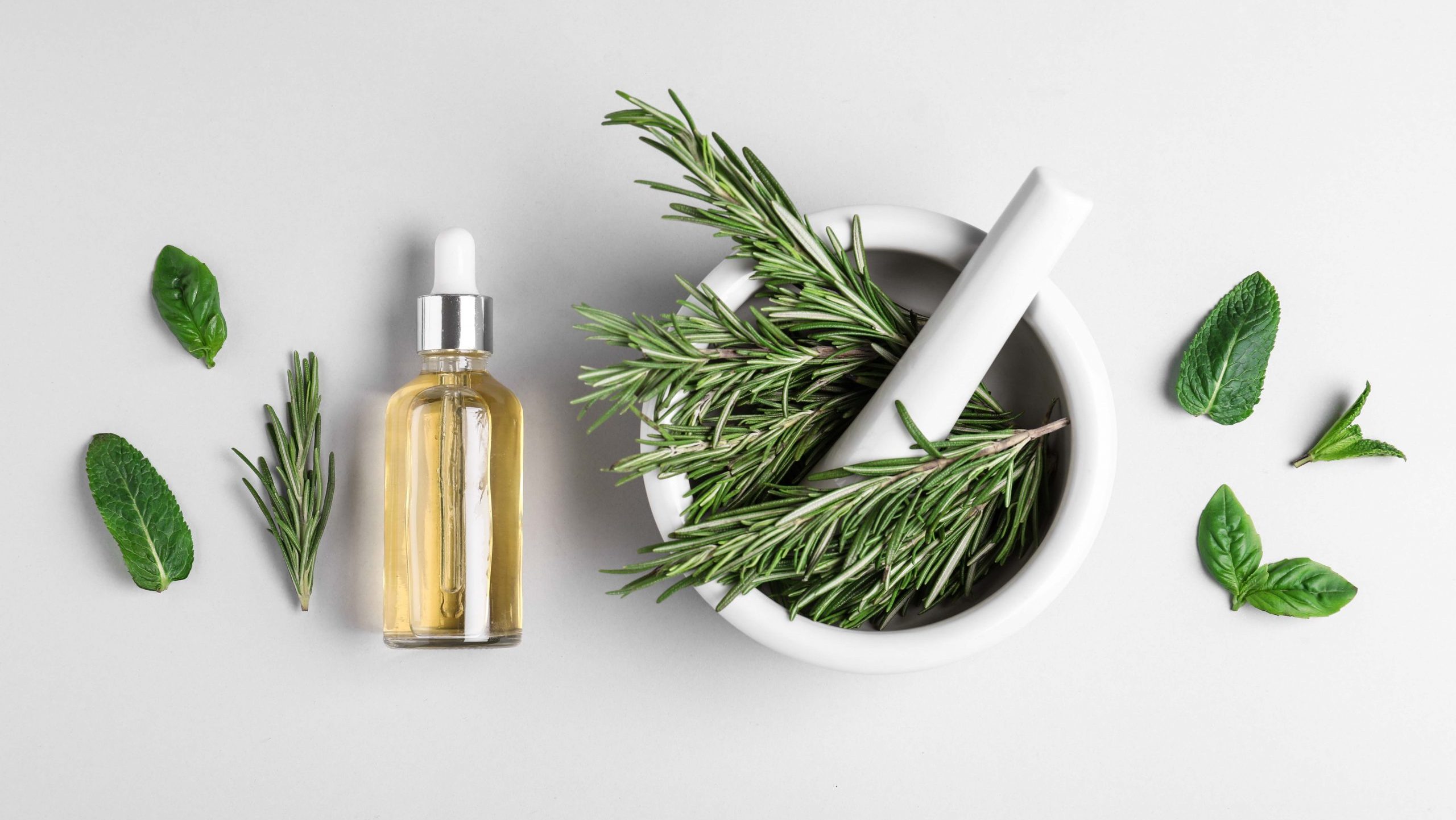rosemary in a mortar and pestle and essential oil
