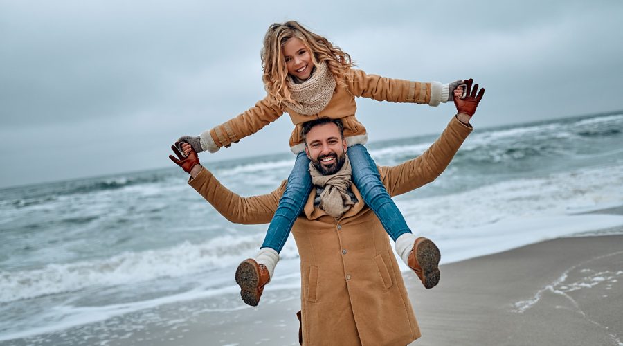 A dad carrying his daugher on his shoulders