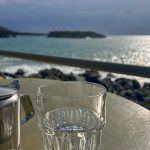 A close-up of a glass with a blurred background of the sea.