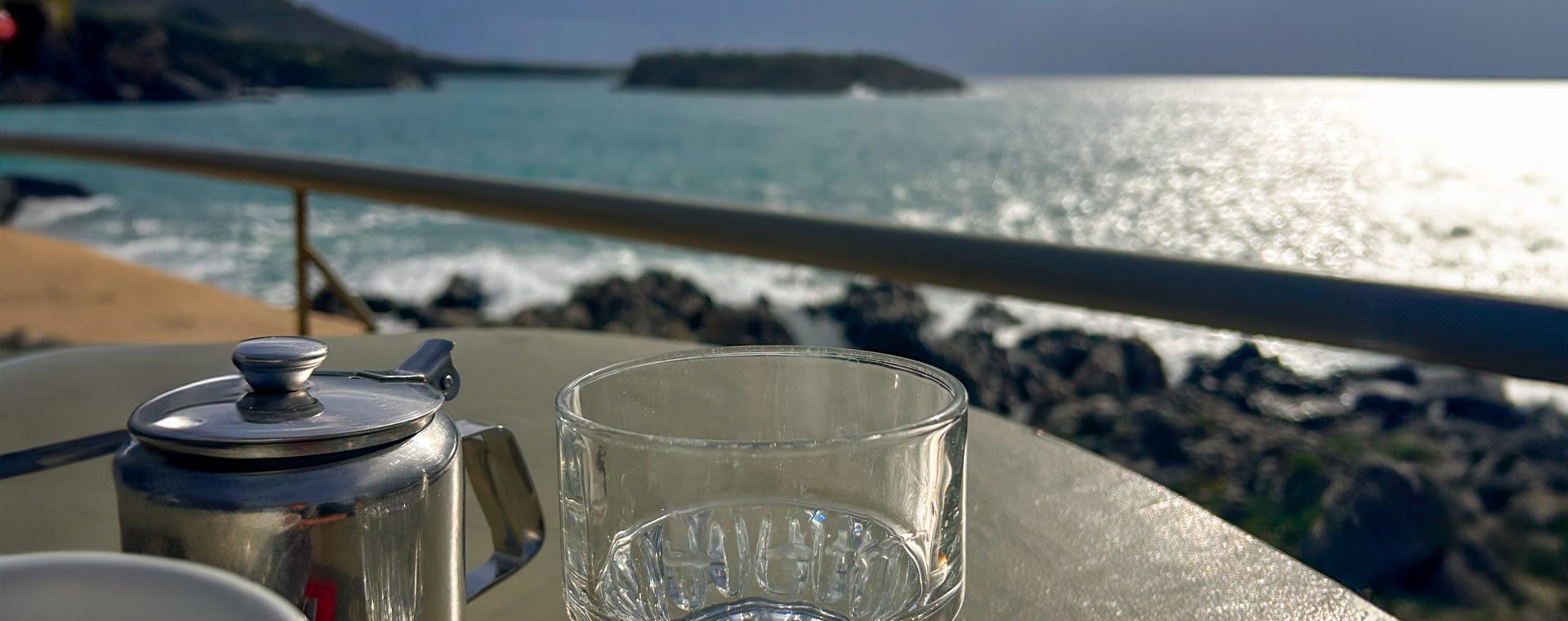 A close-up of a glass with a blurred background of the sea.