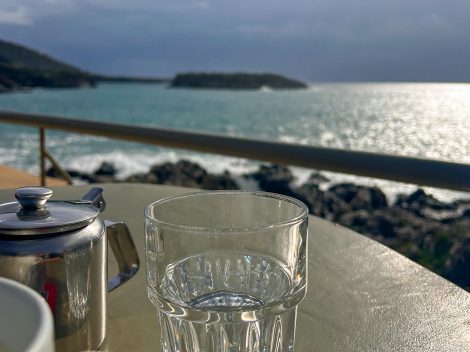 A close-up of a glass with a blurred background of the sea.