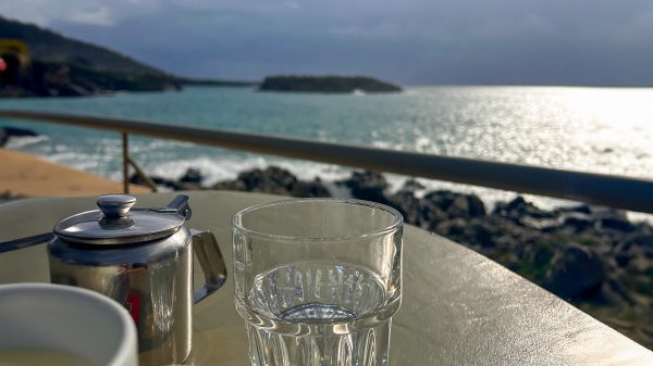 A close-up of a glass with a blurred background of the sea.