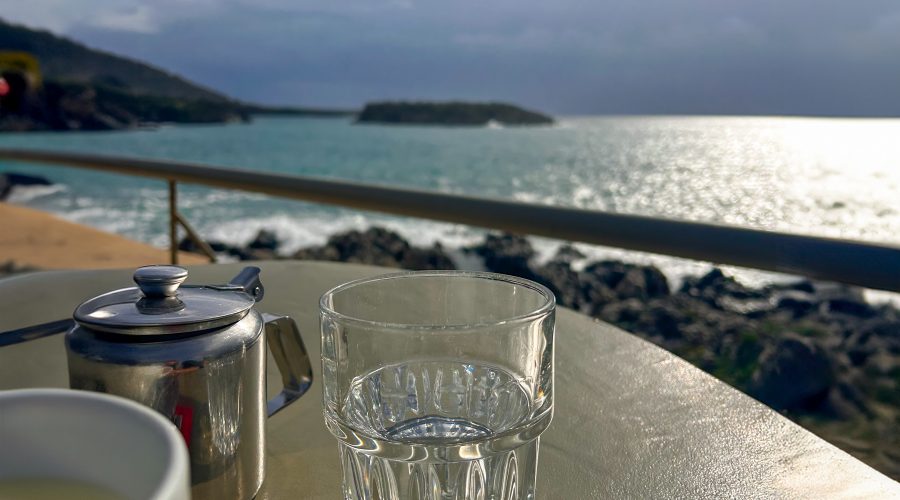 A close-up of a glass with a blurred background of the sea.